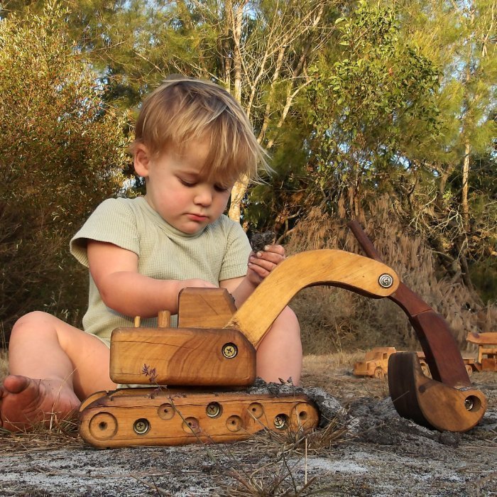 Big luxury Handmade Wooden Toy Excavator Digger. Heirloom. Durable. Functional Arm, boom, blade. Rotating Cab. Pre-school boy playing with toy in Australian Bush.