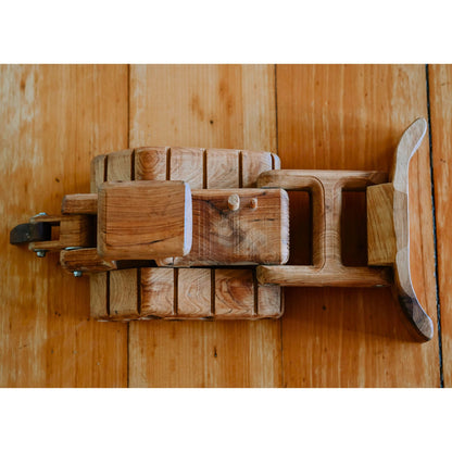 Looking down on a Quality Crafted Handmade Wooden Bulldozer Toy. Showcasing detailed tread and luxurious cedar wood grain against luxurious floorboards. Sturdy functional blade