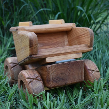 A Rear view of premium handmade wooden dump truck. Wide functional dump tray, rugged and sturdy design. Huge wheels and chunky tread. Luxury Cedar wood grain