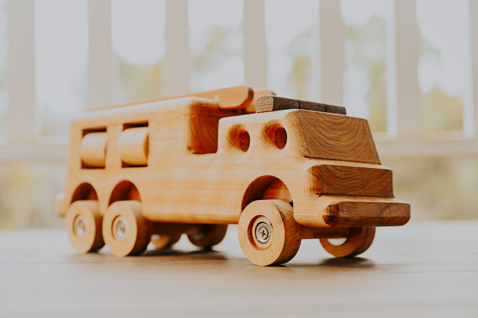 Front angle of premium quality durable wooden fire truck toy. Show casing quality woodworking craftmanship and realistic durable features. 