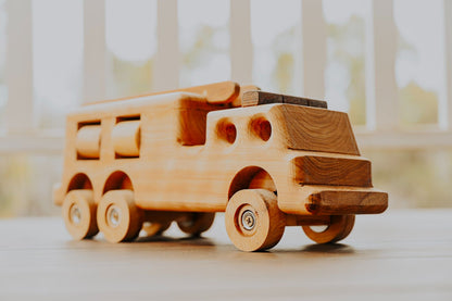 Front angle of premium quality durable wooden fire truck toy. Show casing quality woodworking craftmanship and realistic durable features. 