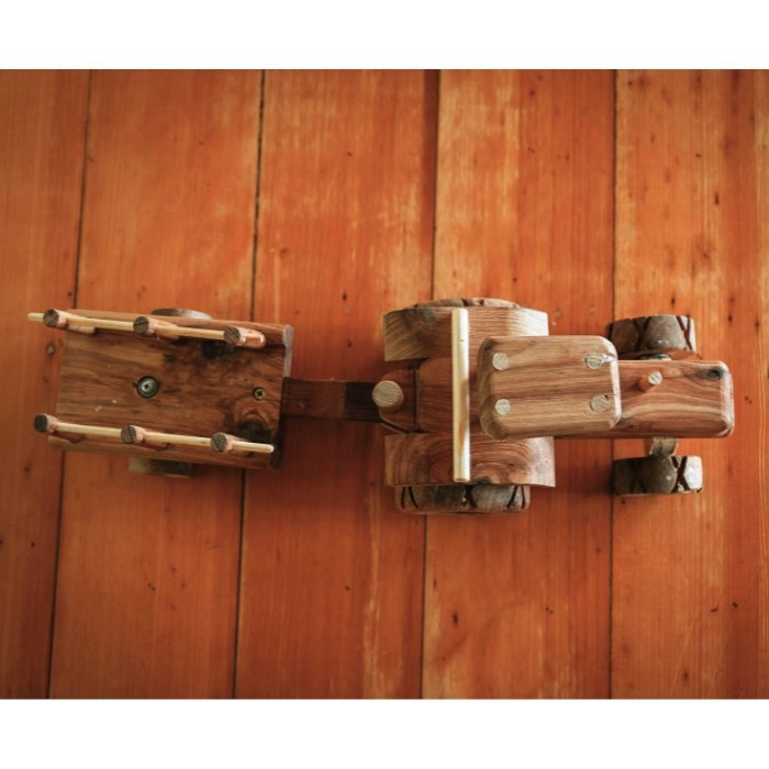 Looking down premium handmade wooden tractor and trailer toy. Set on wooden floorboards in country home. Highlighting detail and luxurious design.