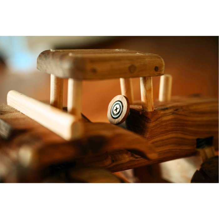 Close Up of a premium handmade wooden tractor toy showcasing detail of luxurious and realistic features of cab and steering wheel.