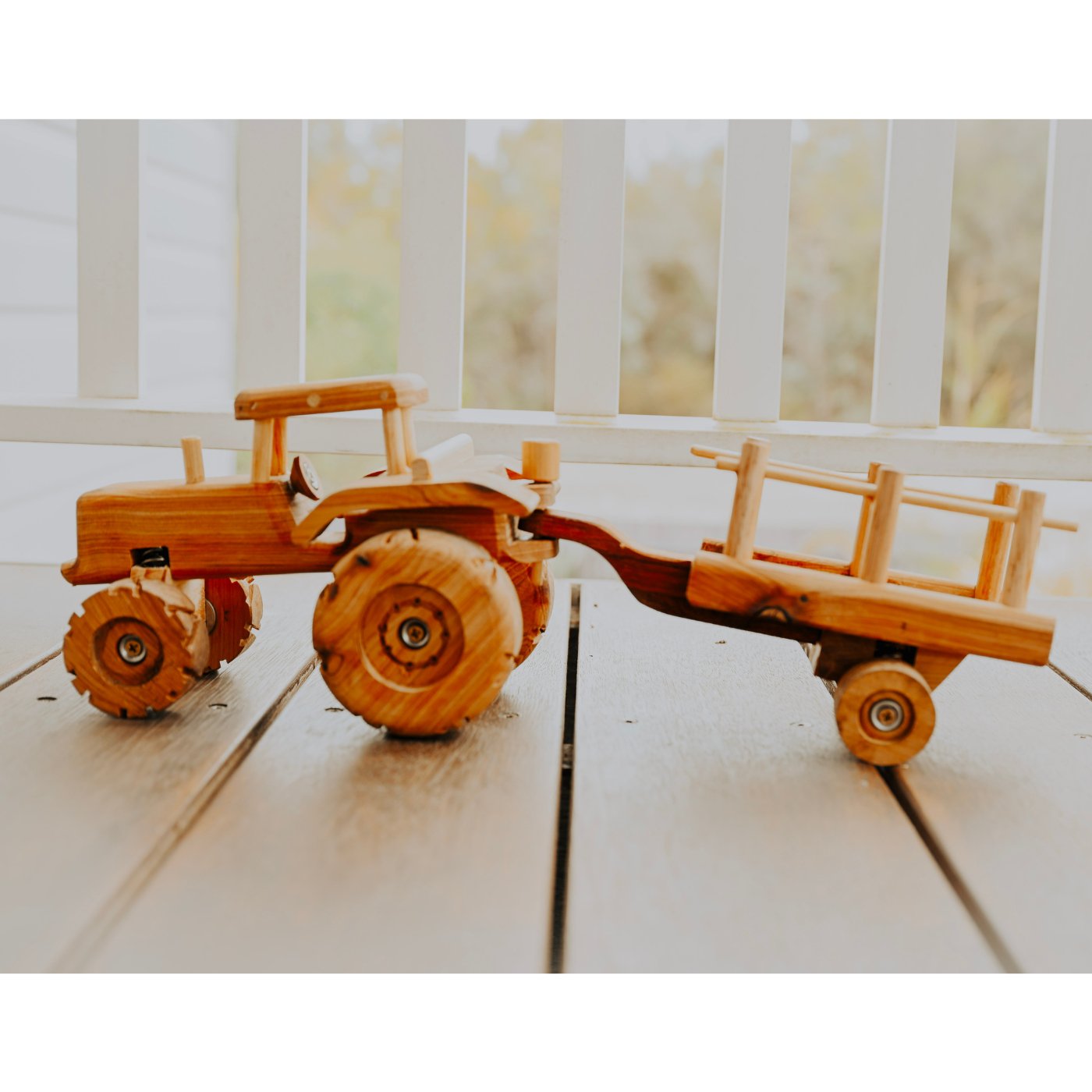 Premium quality handmade wooden tractor and trailer toy. Showcasing detail and suspension. Big Wheels and removable trailer on outdoor deck in queenslander home