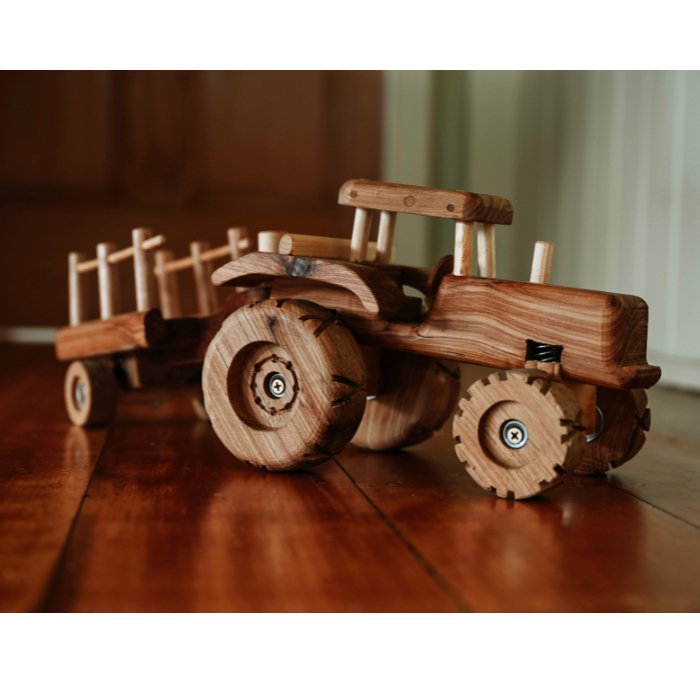 Premium Quality Handmade wooden tractor. Showcasing detail displayed on wooden floorboards.