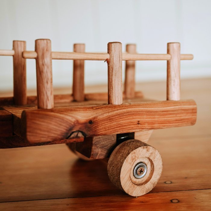 Heirloom Quality Handmade wooden trailer with suspension. Displayed on luxurious wooden floorboards